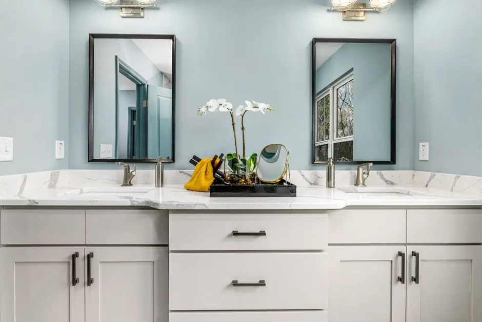 A serene modern bathroom featuring twin sinks, elegant faucets, and decorative mirrors.